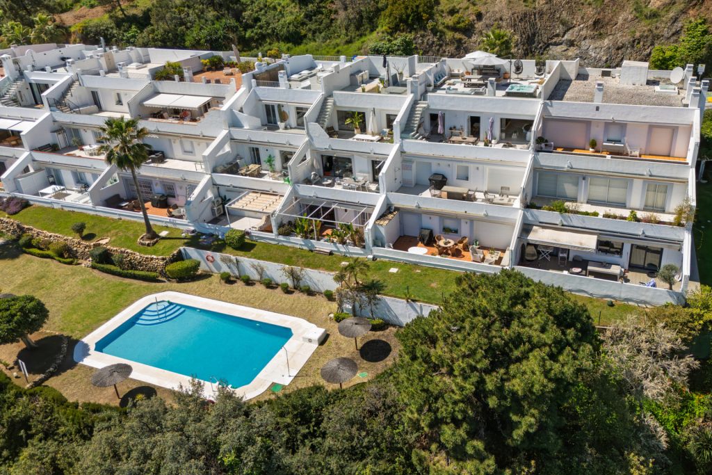 Aerial photograph of apartments, gardens and a communal swimming pool in La Quinta, Benahavís