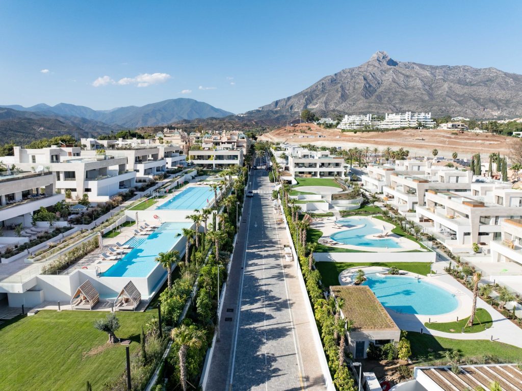 EPIC Marbella’s white residential buildings, landscaped pools and central approach beneath La Concha.