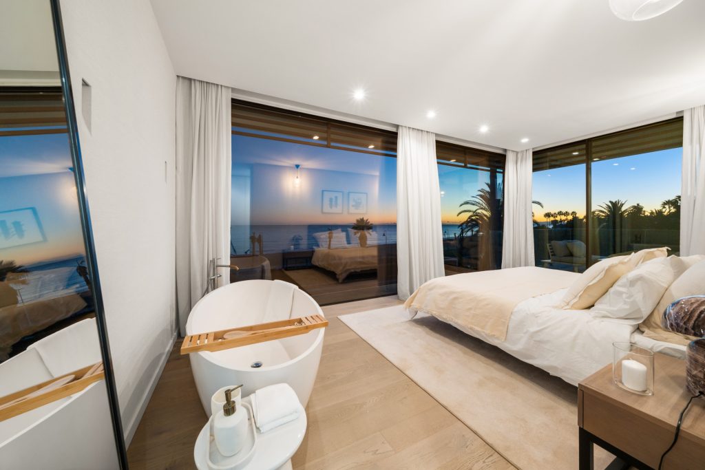 Bedroom with broad windows and a coastal outlook — El Saladillo Beachfront Residence