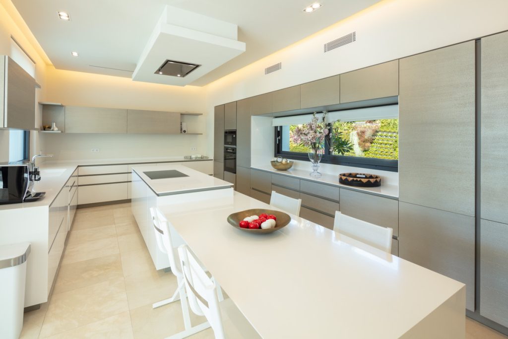 White kitchen with central island — La Cerquilla Residence