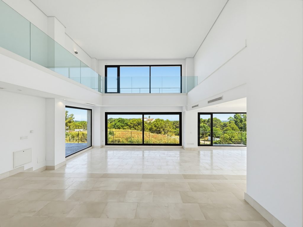 Double-height interior with an upper gallery — La Reserva Residence