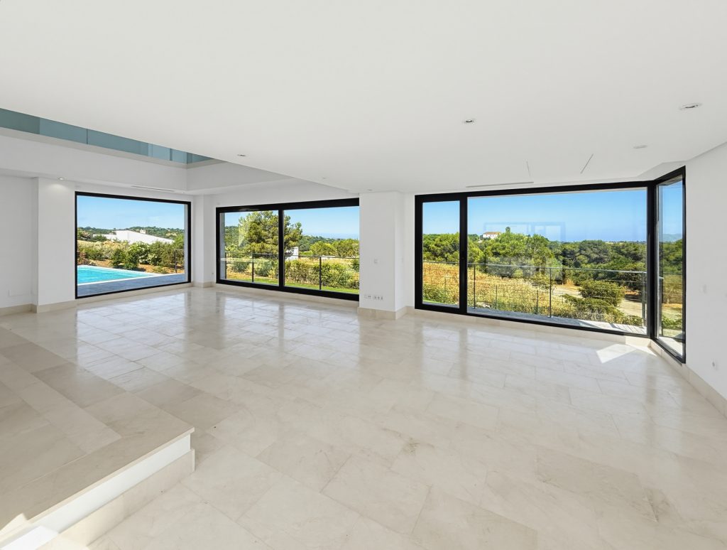 Interior with broad windows overlooking the garden and pool — La Reserva Residence