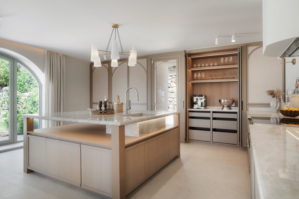 Kitchen with a Taj Mahal quartzite island and bespoke cabinetry — Los Naranjos Garden Residence