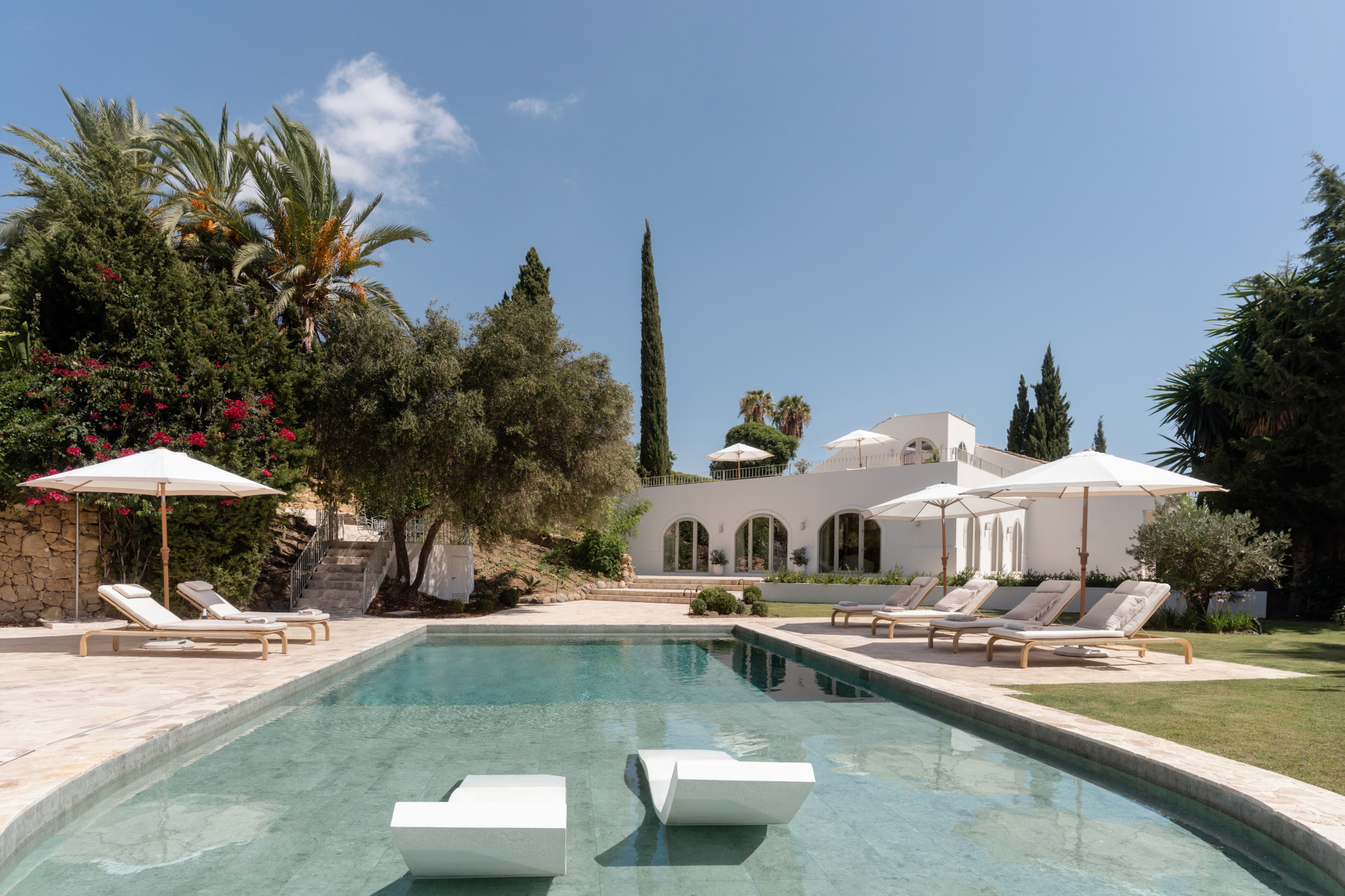 Saltwater pool and white Mediterranean villa surrounded by palms — Los Naranjos Garden Residence