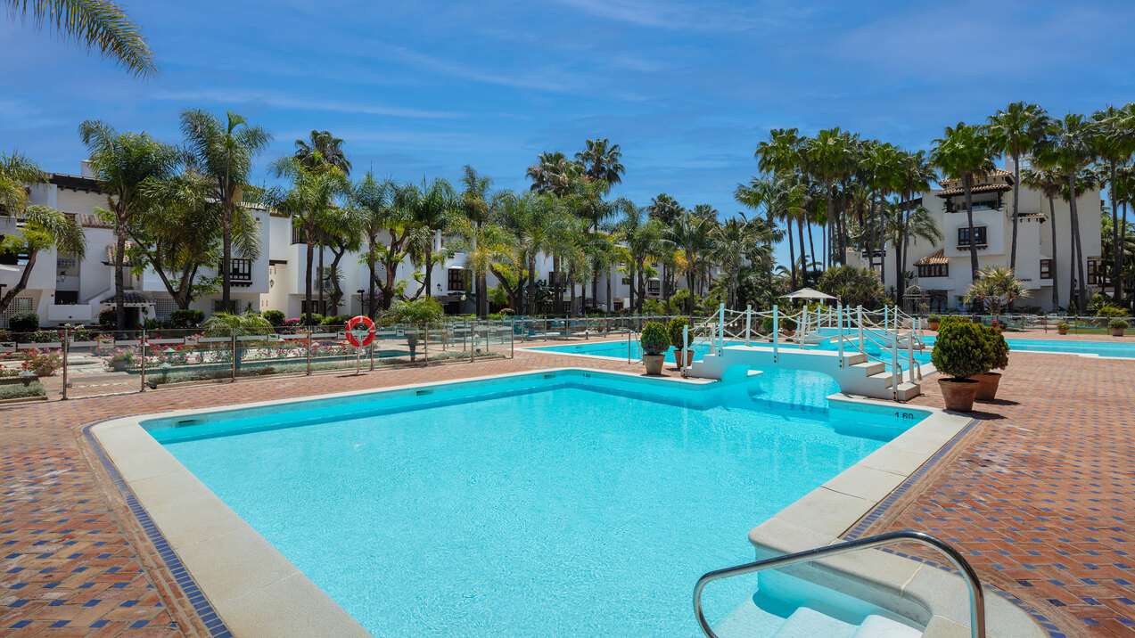 Marina Puente Romano’s communal swimming pools, palm-lined gardens and white residential buildings